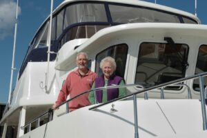 A elderly couple standing together on a boat