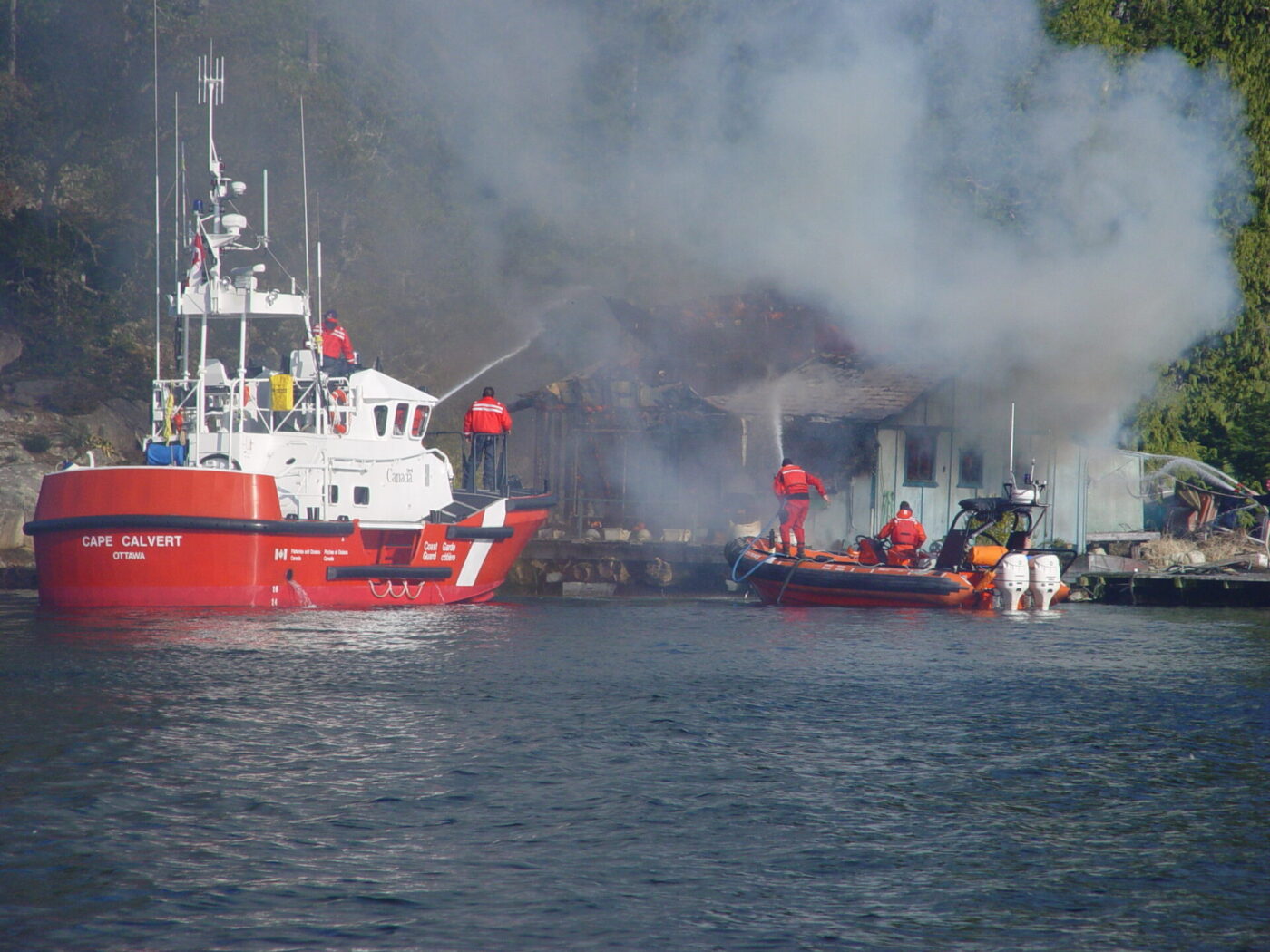 Canada Coast Guard putting out a house fire at waters edge
