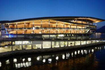 Image of the Vancouver Convention Centre West lit up from the inside at night.